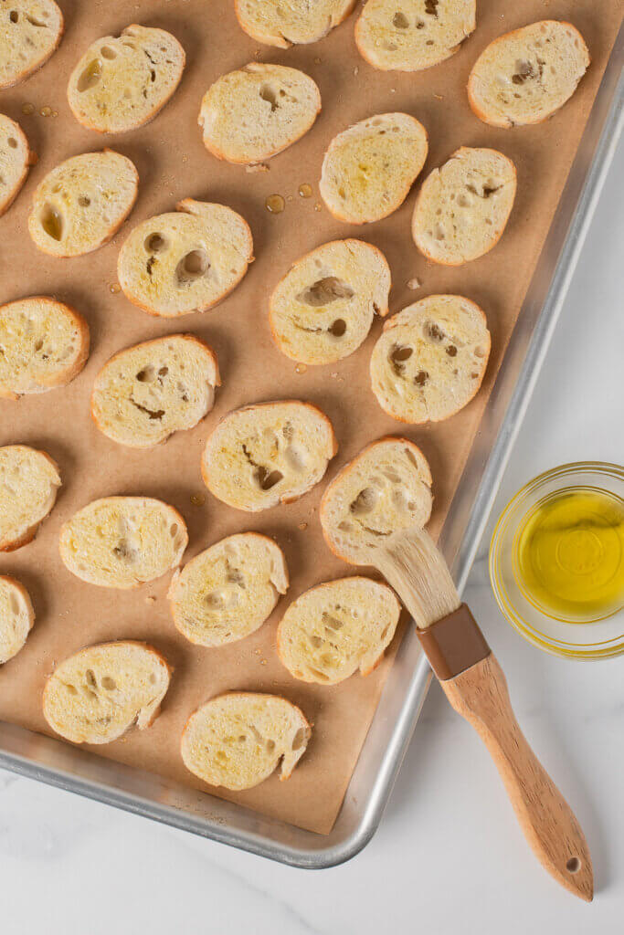 Olive oil brushed over baguette slices before baking crostini