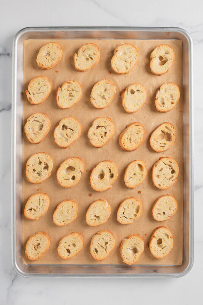 Golden crostini baked on a parchment-lined sheet pan
