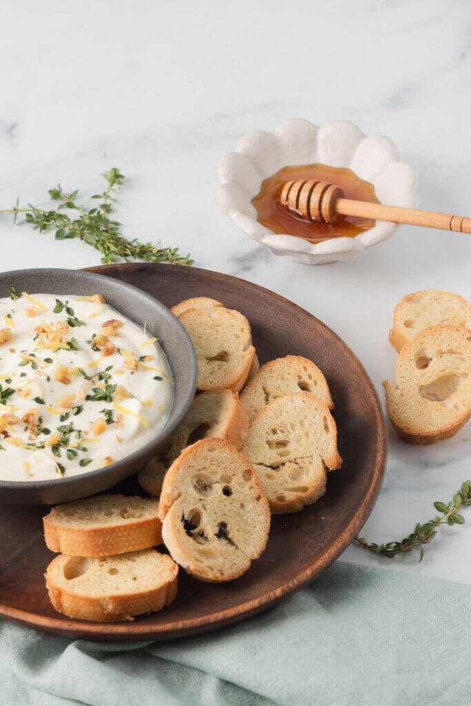 Crostini served with whipped ricotta, honey, herbs, and lemon zest